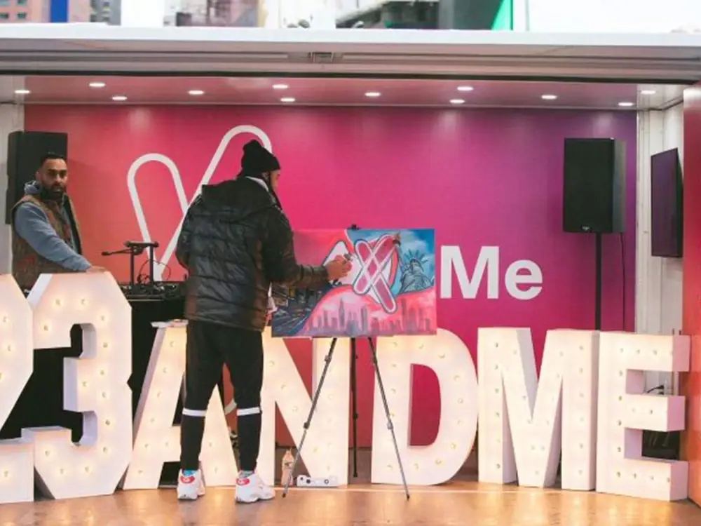 23andMe activation stage with a performer and oversized lettering