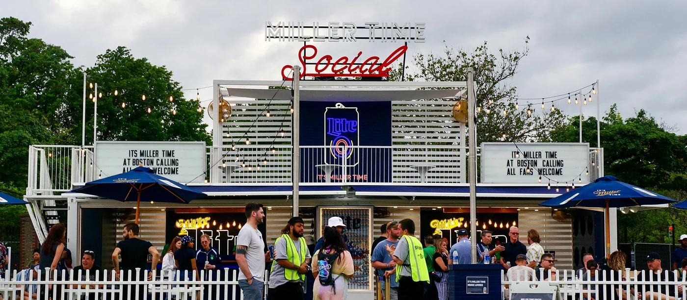 Two-storey Miller Time Social bar with neon sign, upper deck and a queue at the counter